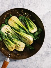 Vertical top view of Bok choy on a fryng pan