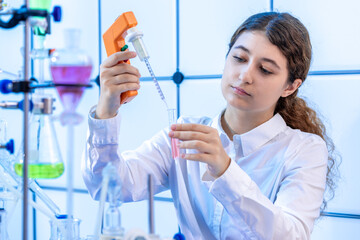 filling a chemical test tube with a dispenser in a chemical laboratory a young woman on doing a scientific experiment