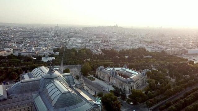 Aerial panoramic tour of Pairs city at refreshing sunrise, featuring iconic Grand palais and Petit Palais with Sacre Coeur at misty horizon 
