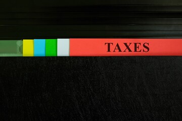 Taxes file in black binder folder. Tax management business and accounting concept.