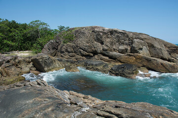 Fototapeta na wymiar .Natural landscape in the Escape of Islands, Barra do Sahy, São Sebastião, Brazil. As Ilhas. Turquoise sea and waves hitting the rocks.