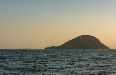 Wheat heap island at sunset. Ilha do Mont&atilde;o de Trigo. Environmental reserve in the sea of S&atilde;o Sebasti&atilde;o, Brazil. In the background, the Alcatrazes archipelago.