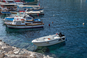 Fishing and pleasure boats are moored at the stone pier. Leisure and business at sea on a sunny day.