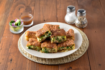 Indonesian Street Food Martabak Telur, Savory pan-fried pastry stuffed with egg, meat, green onion and spices. Served with kuah cuko and acar.