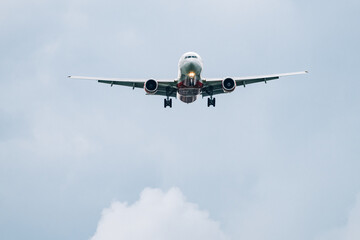 Passenger plane comes in for landing in cloudy weather.