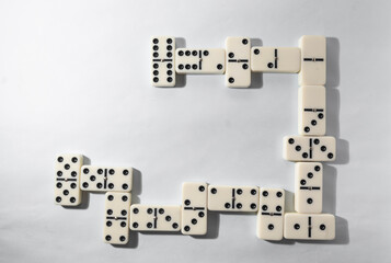 Domino pieces with white background, copy space and various agulos, concept of table games