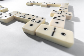 Domino pieces with white background, copy space and various agulos, concept of table games