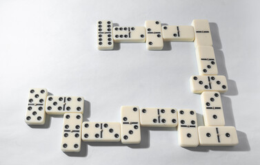 Domino pieces with white background, copy space and various agulos, concept of table games