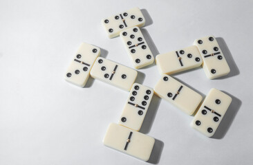 Domino pieces with white background, copy space and various agulos, concept of table games