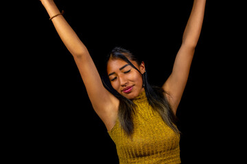 very happy latin woman with arms up on black background