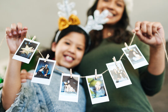 Mother, child and christmas photo garland for family tree decoration for holiday celebration, love and happiness. Woman and girl or daughter in house with photograph or pictures memory banner