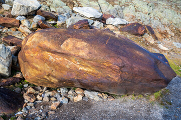 Large orange-brown stone on the ground.