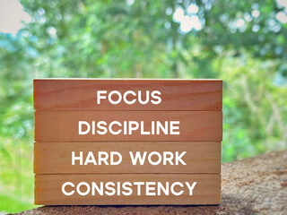 Focus discipline hard work consistency text on wooden blocks background. Inspirational and...