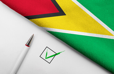 pencil, flag of Guyana and check mark on paper sheet
