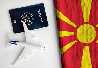 Flag of North Macedonia with passport and toy airplane. Flight travel concept
