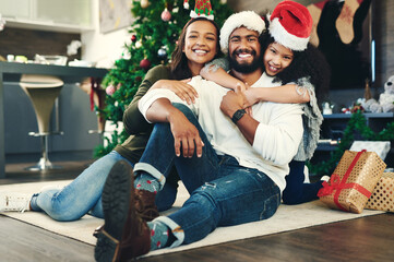 Family portrait, christmas gift and love in holiday celebration, happy smile and relax on floor, decoration and home. Mother, father and girl celebrate festive, happiness and hug at house in brazil