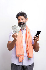 Young indian farmer using smartphone and showing money on white background.