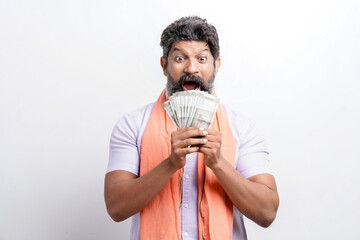 Indian farmer giving shocking expression with money on white background.