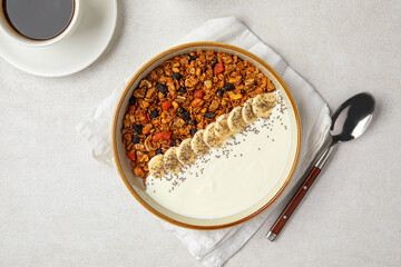 Portion of gourmet granola breakfast with banana and yoghurt