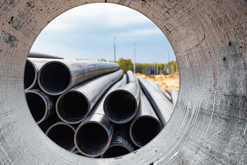 Water pipes for drinking water supply at a construction site. Underground pipeline works. Modern water supply systems for a residential city. Water supply at home. View from the big pipe.