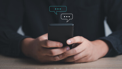 hand using smartphone typing, chatting on application Communication and conversation,mail working, in chat box icons pop up. Social media maketing technology concept.