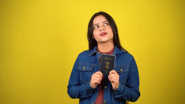 Young woman holding Indian passport, isolated over colour background, Beautiful girl holding visa dreaming, thinking concept