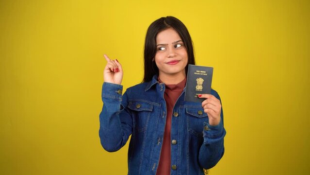 Young woman holding Indian passport, isolated over colour background, Beautiful girl holding visa pointing finger aside, towards copy space