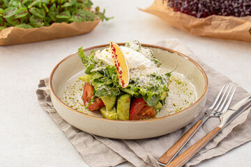 Portion of gourmet avocado salad with tomato and greens