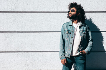 Handsome smiling hipster  model.Sexy unshaven Arabian man dressed in summer jeans jacket clothes....