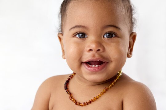 Close-up portrait of baby with cute smile revealing baby teeth