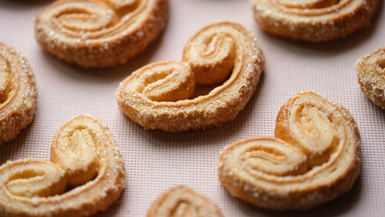 Obraz na płótnie Canvas Fresh baked puff pastry cookies with sugar sprinkles