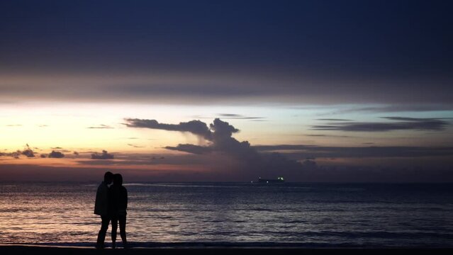 Silhouette of kissing couple on the beach with beautiful sunset background