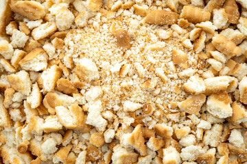 Close-up of a pile dried broken pieces of biscuit, heap of sweet bread crumbs, top view.