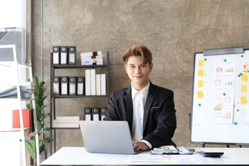 Young businessman working on a laptop in the office. Asian businessman sitting at he workplace in the office.