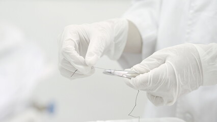 doctor is preparing a needle to pierce a patient's wound.