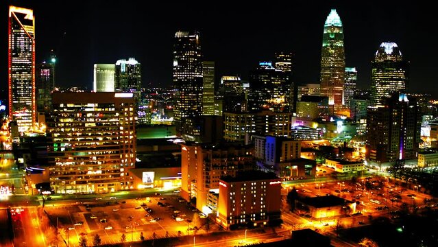 Aerial Shot Of Office Modern Towers In Financial District, Drone Flying Backwards Over Residential Buildings At Night - Charlotte, North Carolina