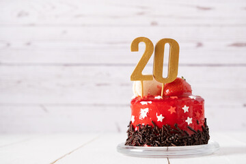 The number Twenty on a red birthday cake on a light background