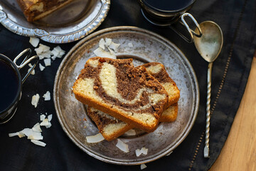 Slices of marble cake with coconut served with coffee
