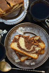 Slices of marble cake with coconut served with coffee