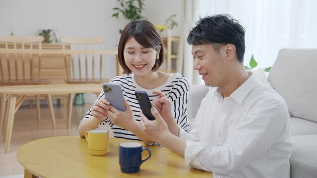 スマホを見せ合う夫婦・カップル