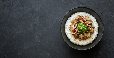 bulgogi with rice on a black background, traditional korean beef dish, asian food, top view, copy...