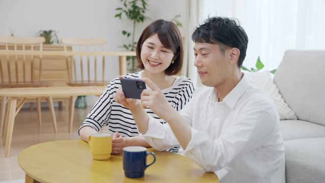 スマホで一緒に動画を見る夫婦・カップル
