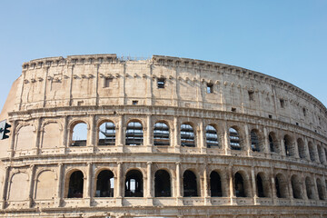 Obraz premium Coliseum (Colosseum), Rome, Italy. Ancient Roman Coliseum is famous landmark, top tourist attraction of Rome. Scenic view of Coliseum with blue sky.