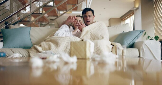 Covid couple, tissue and sofa with blanket in living room, sitting or together while sick, ill and playing. Man, woman and couch with virus, covid 19 or flu in house while throw paper on table