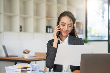 Obraz premium Business asian woman using smartphone for do math finance on wooden desk in office, tax, accounting, financial concept