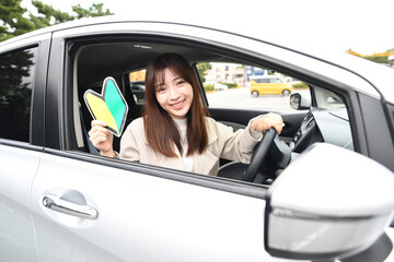 初心者マークを持つ若い女性ドライバー