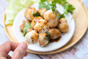 Meatballs on hand with with spicy sauce, Grilled meatball and pork ball, Meat ball on skewers and fresh coriander vegetables, Thai food Asian food Meat balls - pork balls