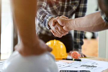 Professional Asian male engineer shaking hands with male architect after the meeting - obrazy, fototapety, plakaty
