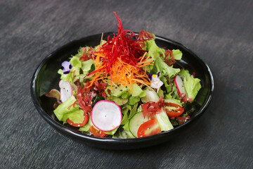 Mix vegetable salad healthy food in black plate.