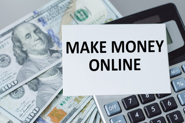 make money online word on a card on the background of a calculator and dollar money on the table, a business concept